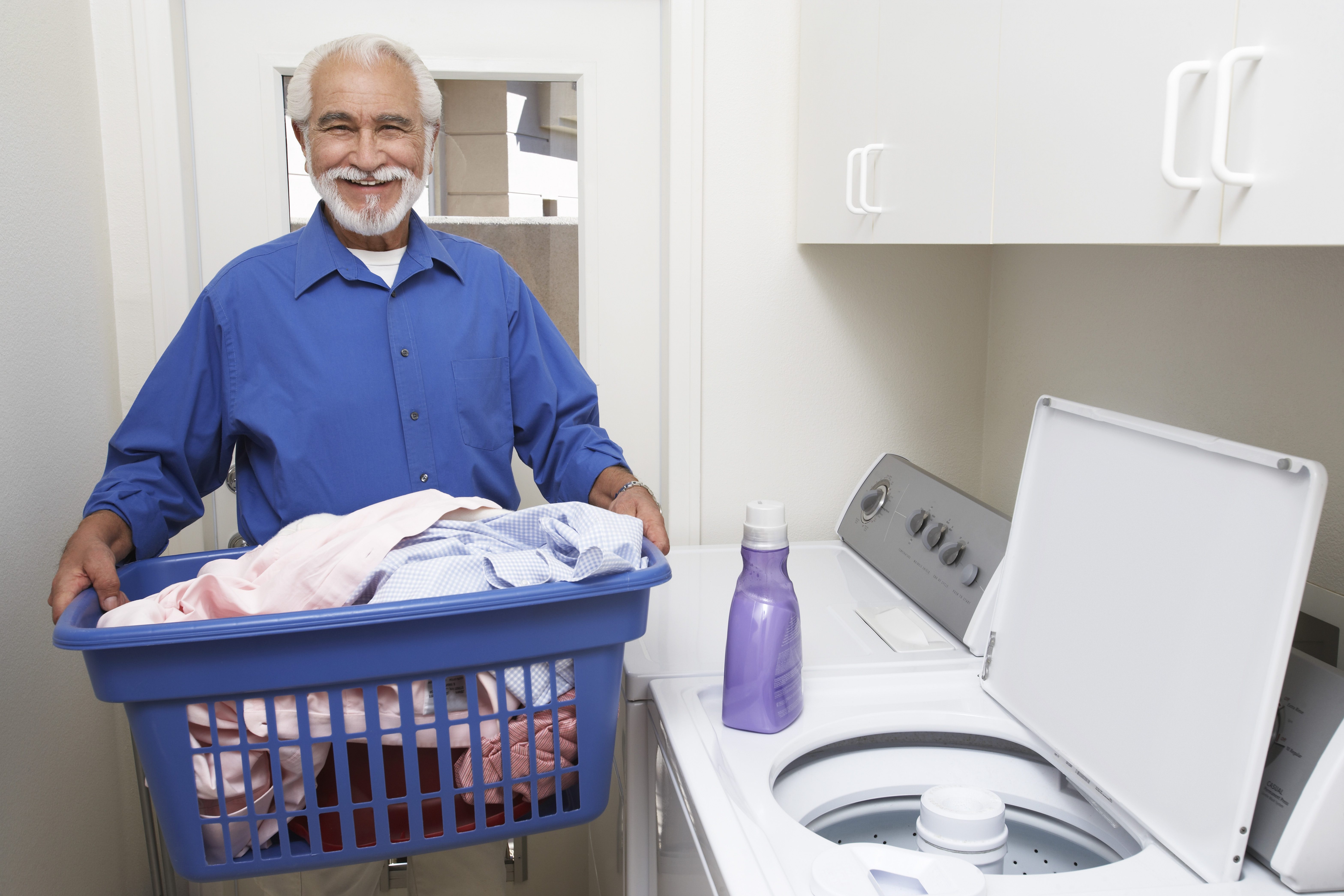 senior man doing laundry in home