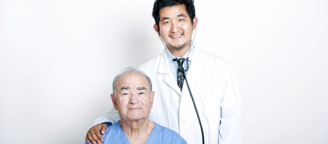 A young Asian Doctor with his hand on the shoulder of a Senior adult patient